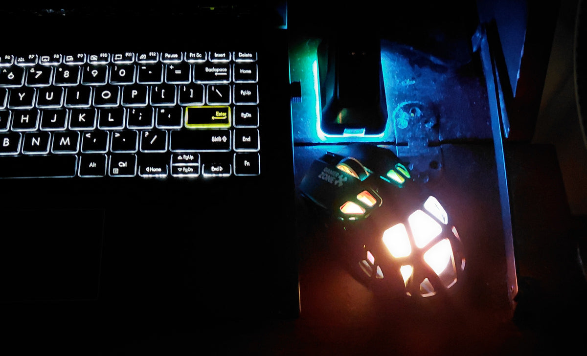 ONIKUMA DM09 mouse and RGB charging dock on a night-time gaming desk beside a backlit keyboard